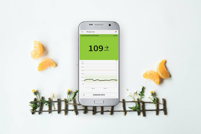 app glucómetro sobre fondo con trozos de mandarina